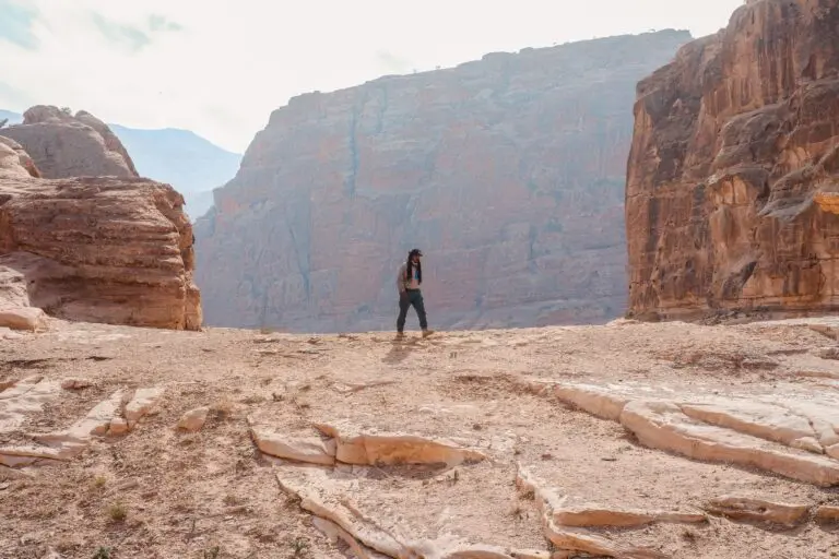 person hiking through a vast desert canyon in Jordan